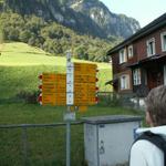 Mäusi betrachtet den Wegweiser in Weisstannen. Viele Wanderungen sind ab hier möglich