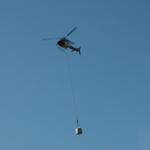 ein Helikopter bringt Material zur Hütte