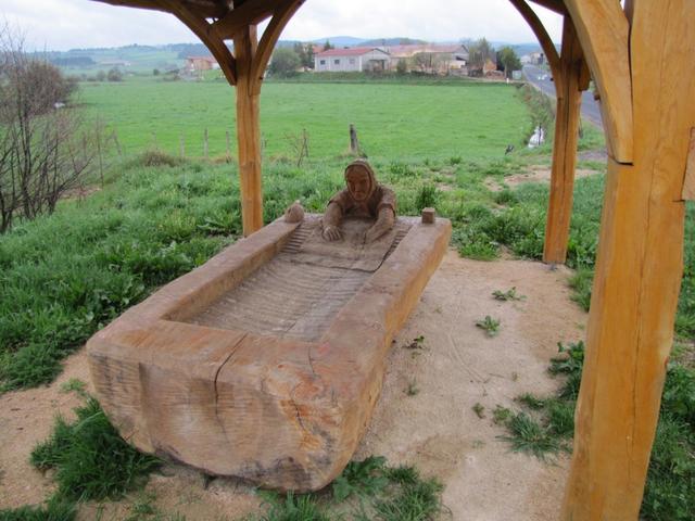 eine Holzskulptur die eine Frau beim Waschtrog symbolisiert