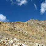 Breitbildfoto Piz Pischa und Piz Cotschen. Die Felswand weist diverse Gesteinsarten und Farben auf