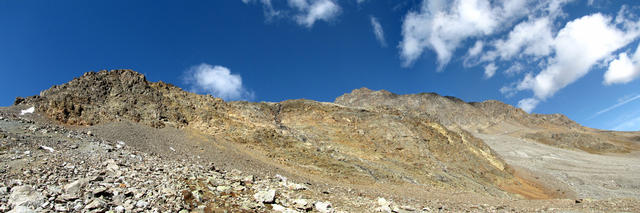 Breitbildfoto Piz Pischa und Piz Cotschen. Die Felswand weist diverse Gesteinsarten und Farben auf