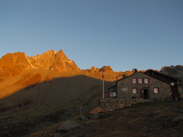 der Piz Kesch färbt sich glühend rot, während dem wir die Hütte verlassen