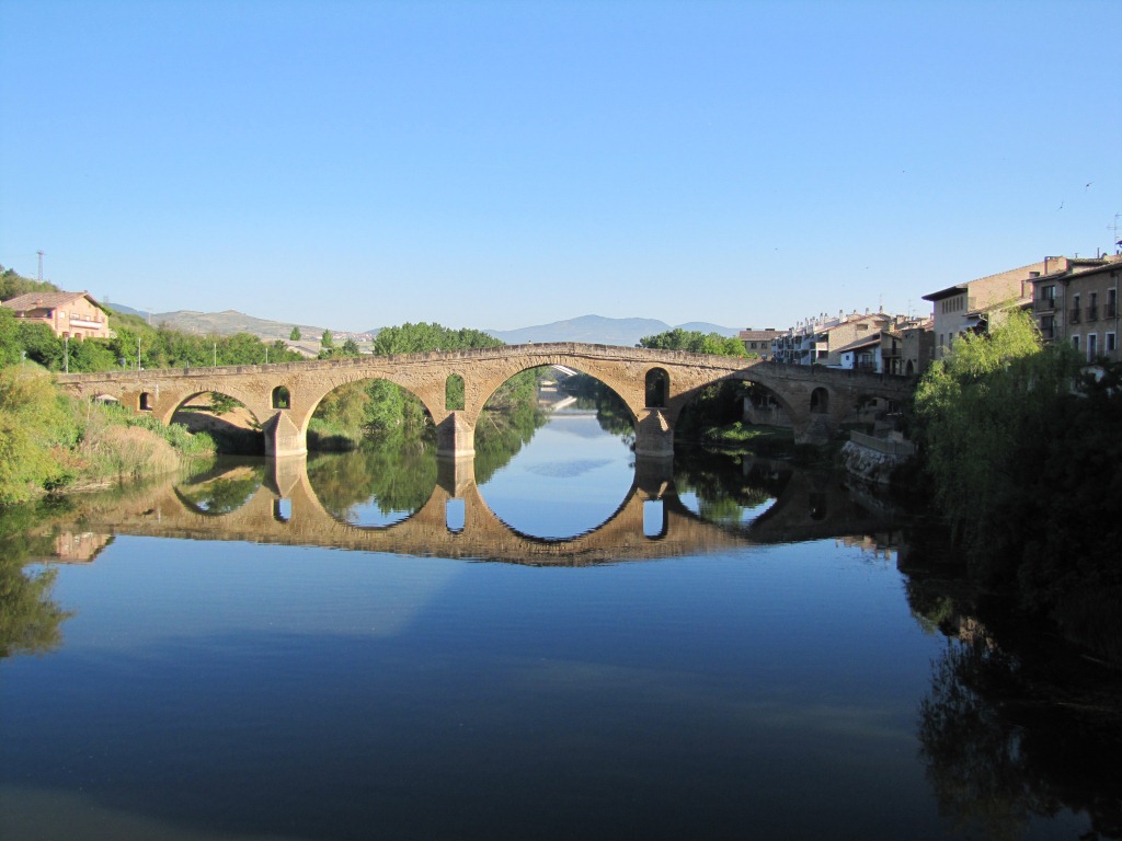 die Brücke spiegelt sich perfekt auf dem langsam dahin fliessenden Fluss Arga