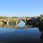 die Brücke spiegelt sich perfekt auf dem langsam dahin fliessenden Fluss Arga