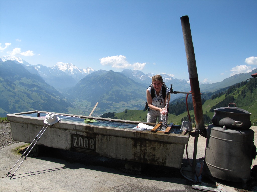 Mäusi erfrischt sich bei einem Brunnen auf der Alp Unterniesen