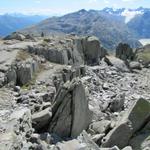 zwischen grossen Grantiblöcken führt der Bergpfad bei schönster Aussicht abwärts