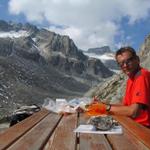 Franco bereitet auf der Terrasse der Bächlitalhütte das Mittagessen vor