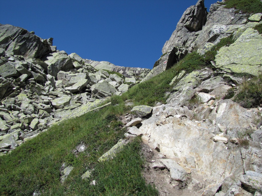 der Bergpfad führt hinauf zu einem kleinen Einschnitt