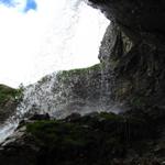 der Bergweg führt direkt unter dem Wasserfall hindurch