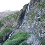 der Bergpfad kreuzt ein Wasserfall