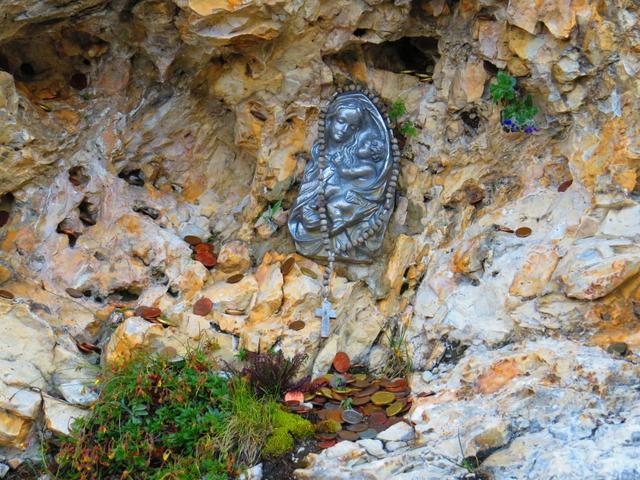 neben dieser Madonna werden in allen Löcher und Ritzen an der Felswand, Münzen hineingesteckt