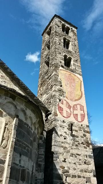 der Campanile mit den Wappen vom Bleniotal und der Leventina wird durch das Urner Wappen überragt