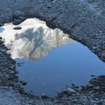 die eisbedeckten Berge spiegeln sich im kleinen Bergsee