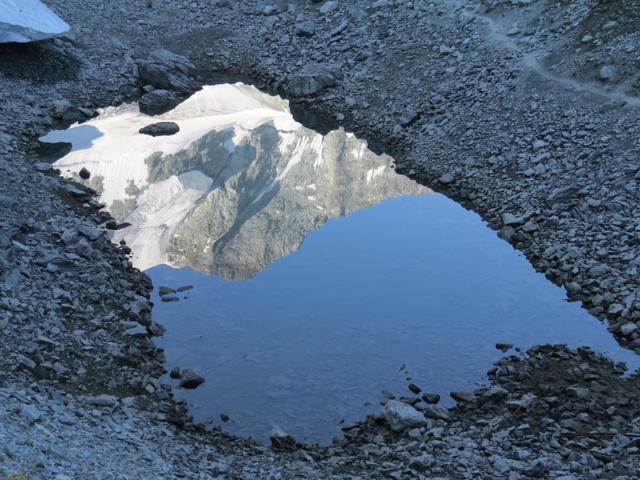 die eisbedeckten Berge spiegeln sich im kleinen Bergsee