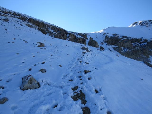 der Weg über die steilen, schneebedeckten und vereisten Schuttfelder wird uns zu heikel. Wir ziehen die Steigeisen an