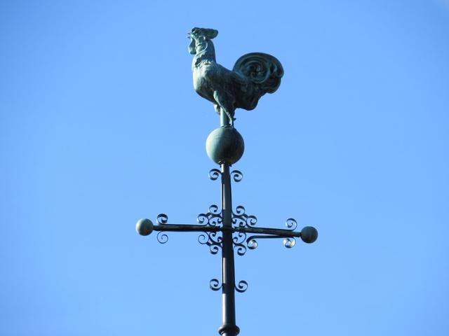ein stolzer Hahn schaut vom Kirchendach hinunter