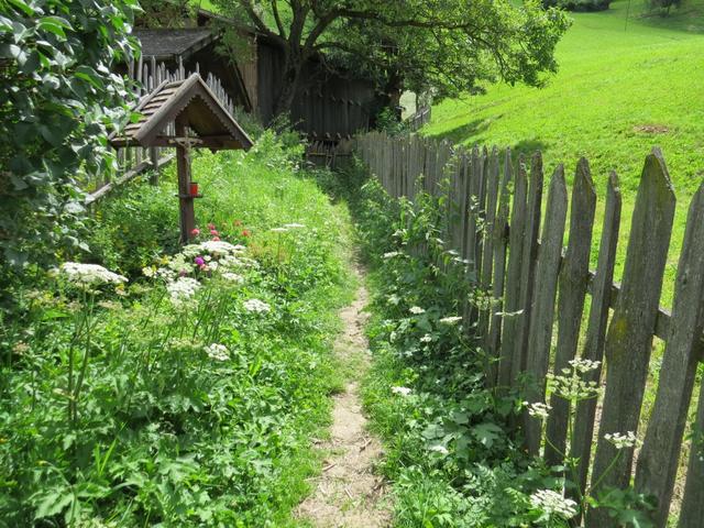 der Weg führt an einem schönen Holzkreuz vorbei