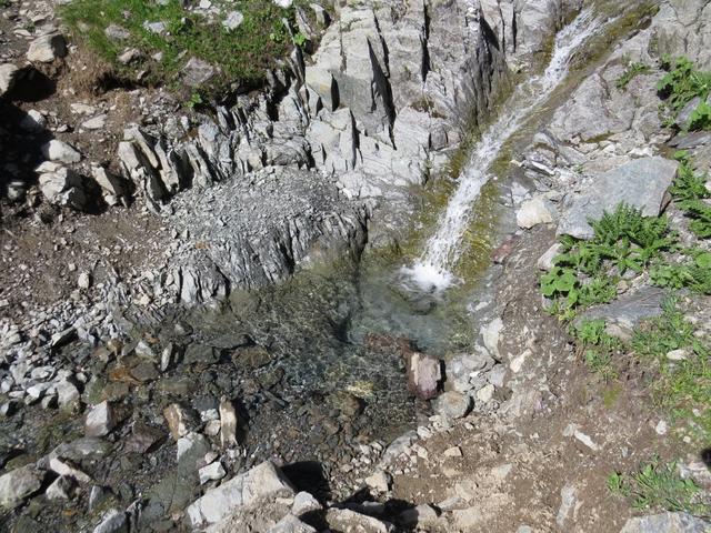 im Talgrund schlängelt sich ein kleiner Gebirgsbach abwärts Richtung Stausee