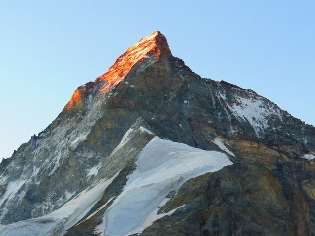 die aufgehende Sonne färbt das Matterhorn in einem glühendem rot