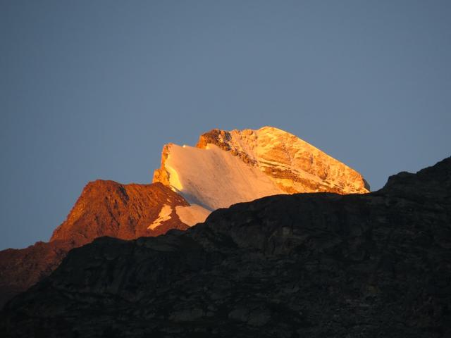 Blick hinauf zum Brunegghorn das von der aufgehenden Sonne in einem glühendem Rot eingetaucht wird