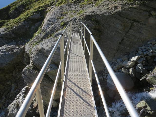 der reissende Bach wird auf einer Brücke überquert