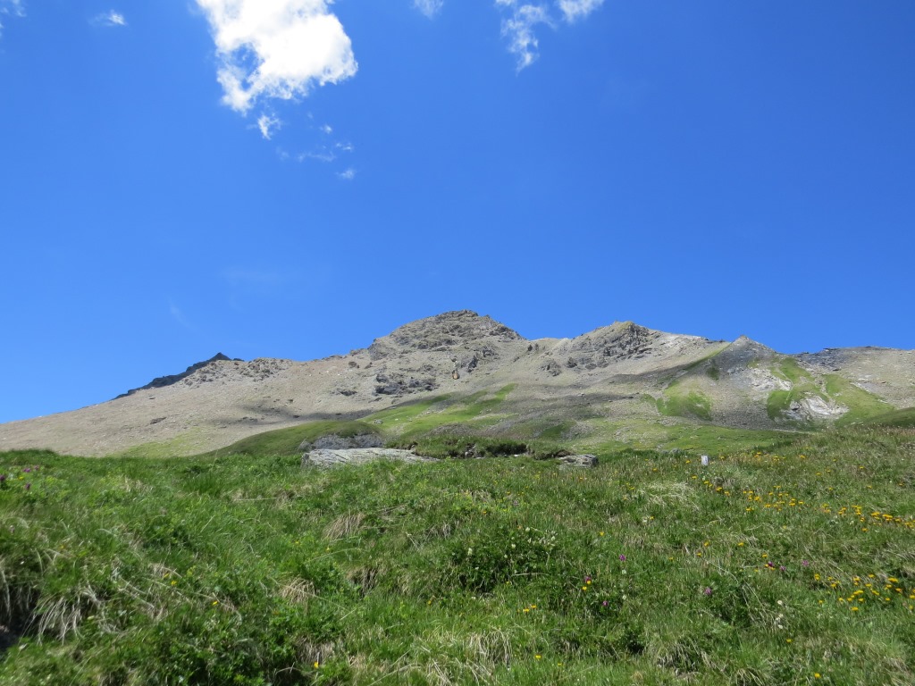 Blick hinauf zum Piz Curvér, der hinter der Kirche in den Himmel ragt