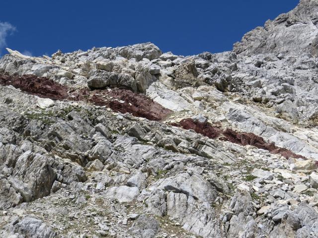 hier müsste man Geologe sein. Der vorherrschende hellbraune Felsen wird durch rostrote Einschüsse unterbrochen