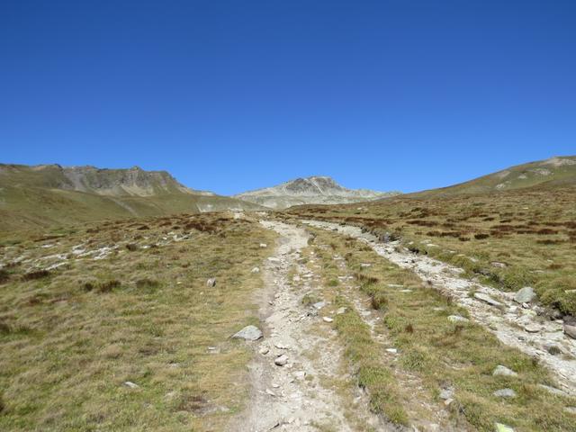 über eine Rechtskurve biegt der Wanderweg in ein weites Tal hinein