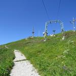 von der Bergstation 1967 m.ü.M. geht es auf breitem Weg, vorbei an Antennenmasten und Skiliften, hinauf auf den Gipfel 2042 m.