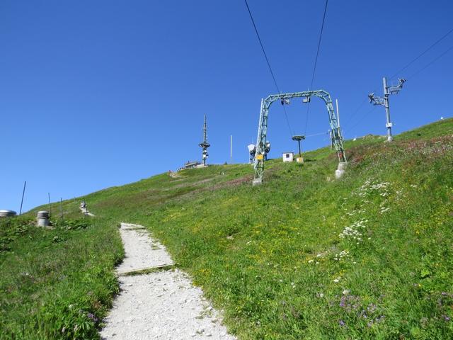 von der Bergstation 1967 m.ü.M. geht es auf breitem Weg, vorbei an Antennenmasten und Skiliften, hinauf auf den Gipfel 2042 m.