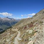 hinter einer Kurve zeigt sich geradeaus, am Hang zum ersten Mal die Segantini Hütte als nächstes Etappenziel