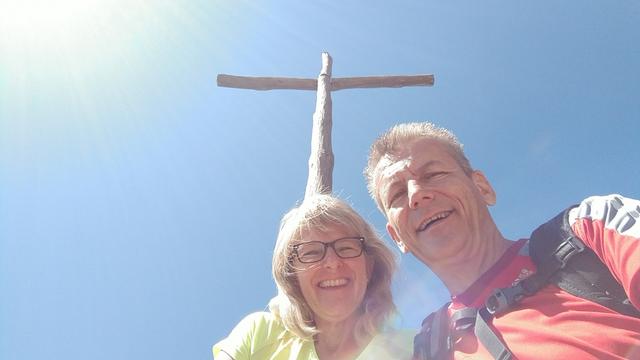 Erinnerungsfoto aufgenommen beim schlichten Holzkreuz