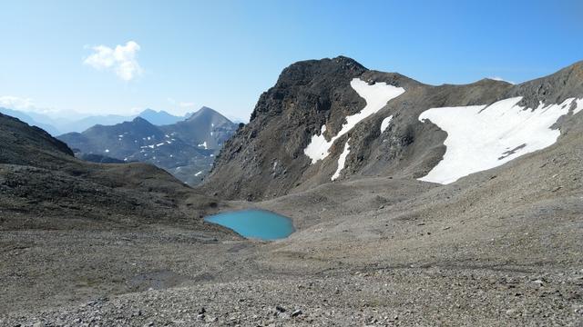 über Schutt laufen wir abwärts zu einer kleinen Ebene mit Bergsee