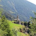 zwischen den Lärchen taucht vor uns die Kirche von San Romerio auf