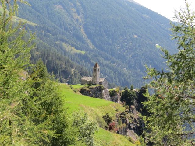 zwischen den Lärchen taucht vor uns die Kirche von San Romerio auf