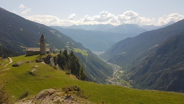 mutig steht die Kirche am Rand der mächtigen Felswand, die Hunderte Meter senkrecht abfällt zum Lago di Poschiavo