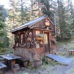 bei einer Waldhütte mit Bänken, das wie ein kleines Hexenhaus aussieht...