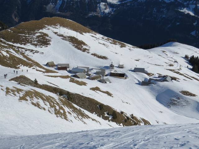 vor uns erscheint das kleine Hüttendörfli Breitenfeld, eingebettet in die weisse Winterlandschaft