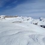 der Pfad führt über den breiten Grat, der sich wie ein weisser Rücken durch die Winterlandschaft zieht