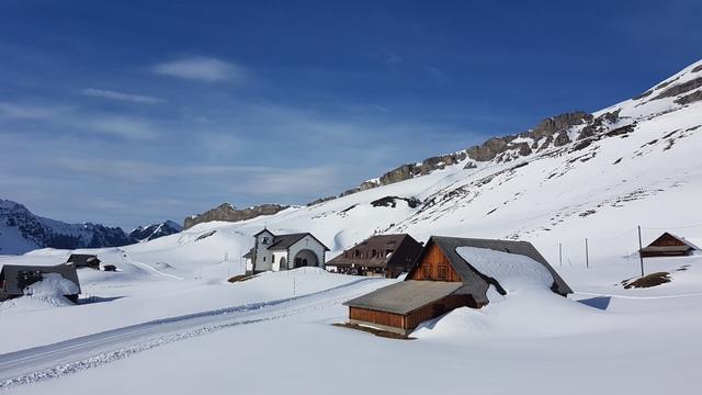 ein kleines, stilles Dörfli, eingebettet in die weite Schneemulde und von der Sonne sanft beleuchtet