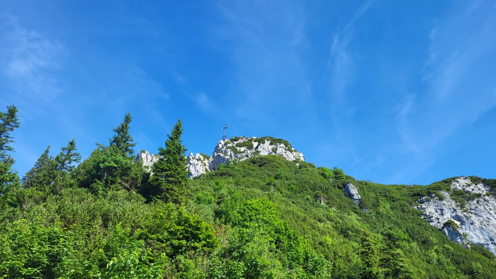 direkt über unsere Köpfe das grosse Chiemgau-Gipfelkreuz beim Kampenwand Ostgipfel