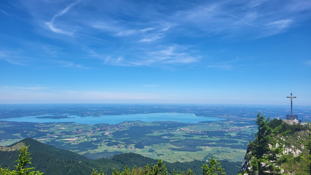 während wir zum Gipfelkreuz laufen, geniessen wir eine traumhafte Aussicht auf die Ebene und den Chiemsee