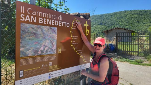 meine Maus bei einer Infotafel vom Cammino di San Bendetto. Sie zeigt auf die erste Etappe