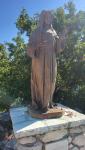 Bronzestatue der hl. Rita die eine Rose in den Händen hält