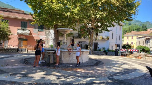 spielende Kinder beim Brunnen auf dem Dorfplatz von Licenza