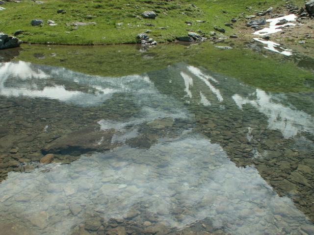 die Berge spiegeln sich im kleinen Bergsee neben der Fridolinshütte